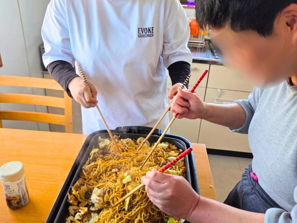 グループホーム内で焼きそばパーティーを楽しむ利用者たち